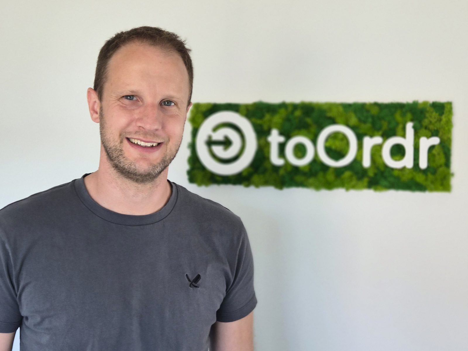 Julian von Westberg, Geschäftsführer der red root GmbH, vor dem toOrdr Logo